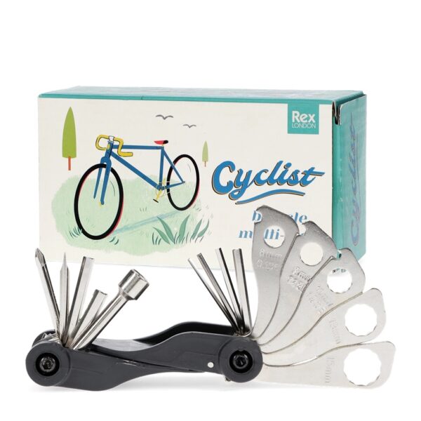 A black multi-tool with various silver metal attachments fanned out, positioned in front of a blue and white retro-style cardboard box featuring a vintage bicycle illustration.