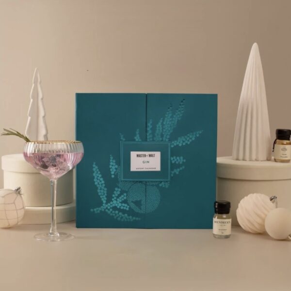 Teal Gin Advent Calendar styled in a festive scene alongside a cocktail glass, ornaments, and mini gin bottles