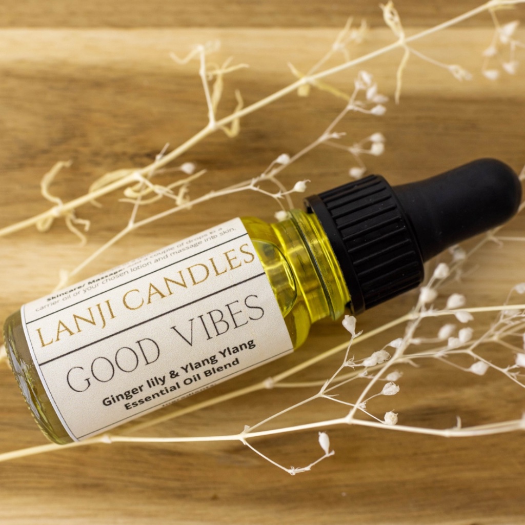 Good Vibes Ginger Lily and Ylang Ylang Essential Oil Blend 10ml glass bottle with pipette laying on wood with dried white flowers by Abode Home & Gifts