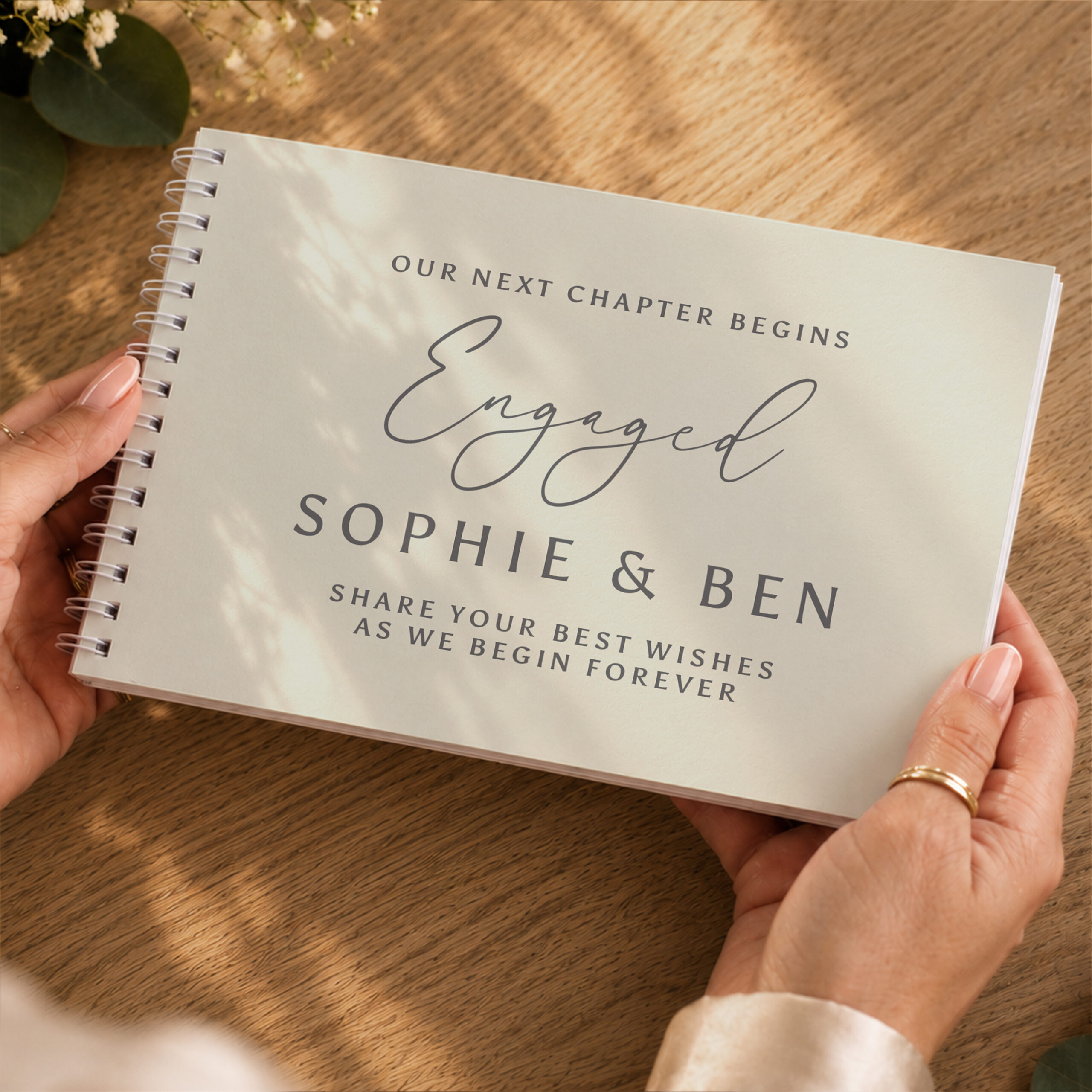 Hands holding the Personalised Engagement Guest Book reading Our Next Chapter Begins Engaged Sophie and Ben by Abode Home & Gifts