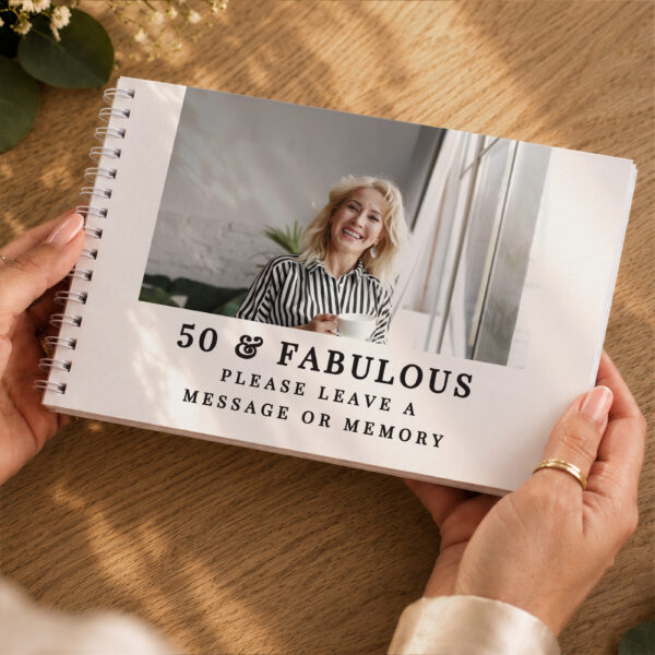 Hands holding the Personalised Photo Upload Guest Book featuring a portrait photo and 50 & Fabulous text by Abode Home & Gifts